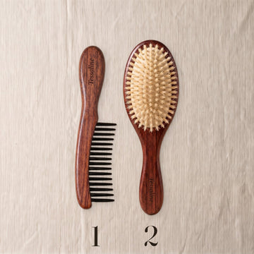 A wide-tooth comb marked 1 and a boar bristle brush marked 2, side by side on linen