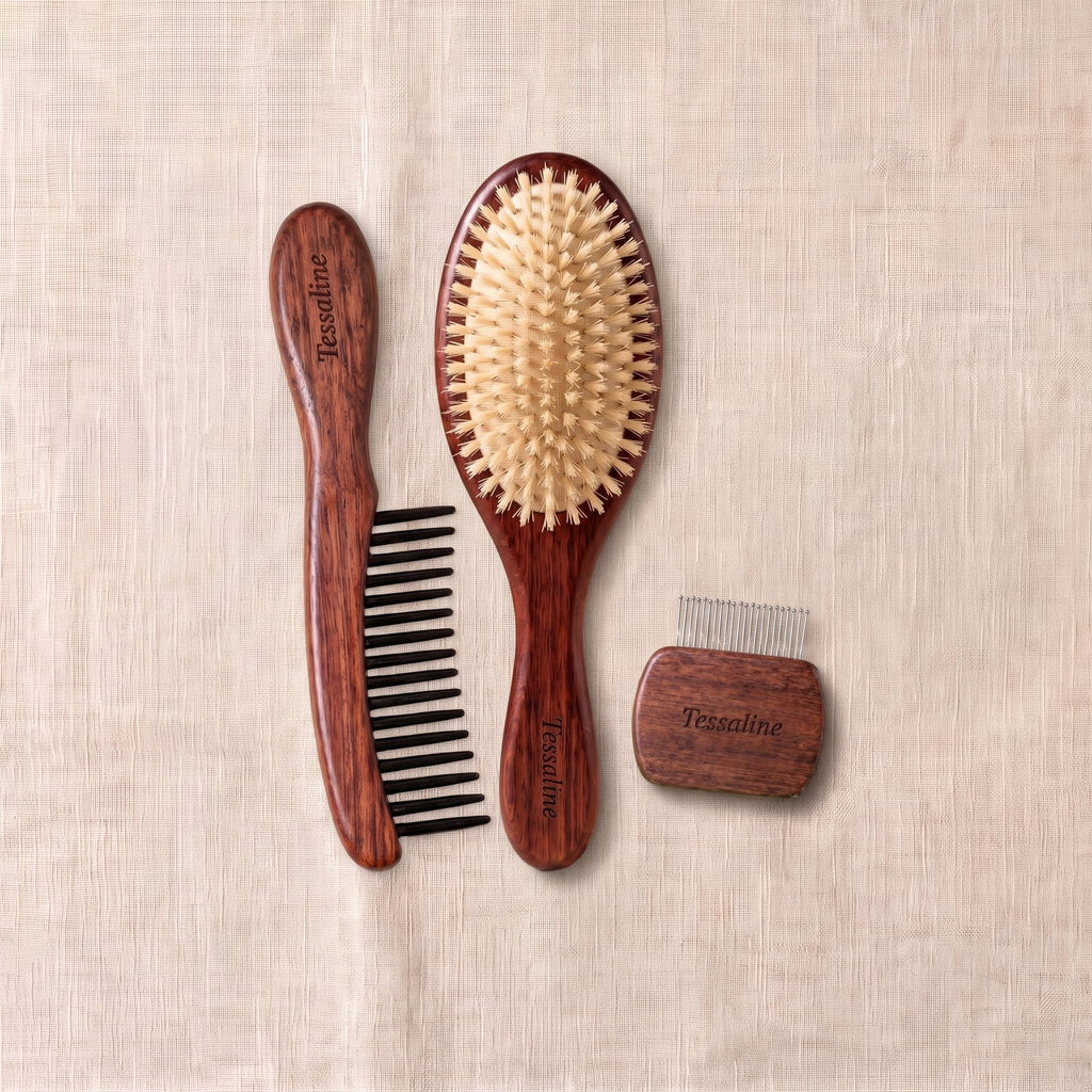 A wide-tooth comb, The Soft Grade boar bristle brush and a brush cleaner, laid together on linen