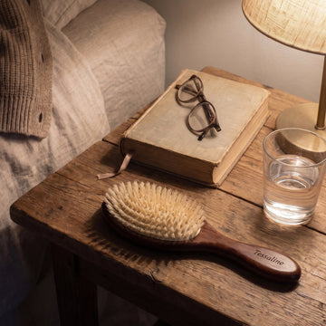 The Soft Grade brush on a bedside table next to a lit lamp