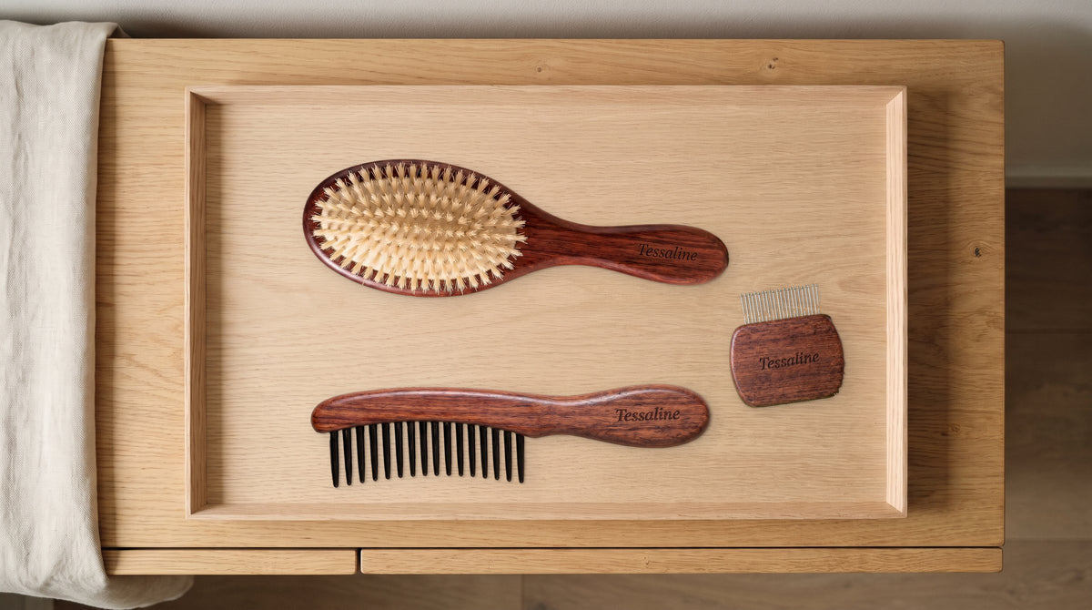 The Soft Grade brush, a wide-tooth comb and a brush cleaner on a wooden tray